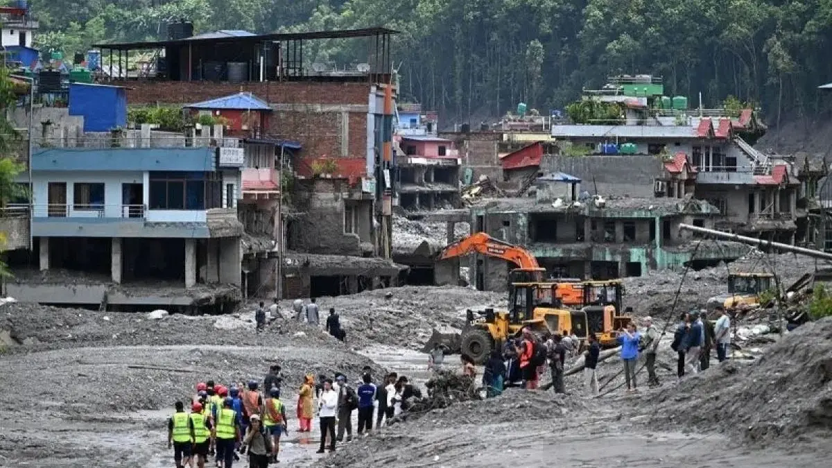 Banjir Bandang Perbatasan Nepal-China: 691 Orang Tewas, 3.000 Hilang Para pekerja menggunakan ekskavator untuk membersihkan lumpur pascabanjir bandang di Dhunge Bazaar, Distrik Nu