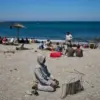 Seorang migran yang menyeberang ke Spanyol dari Maroko berdoa di pantai di kantong Spanyol Ceuta, Minggu, 2 Ag