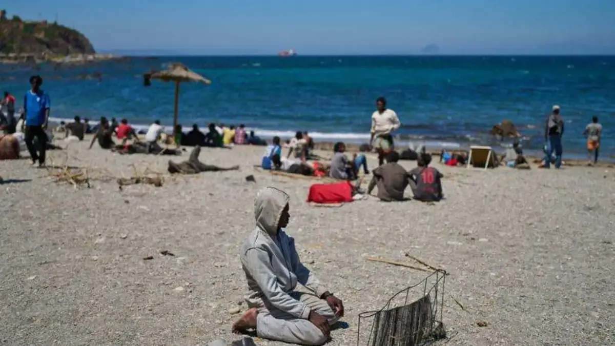 Seorang migran yang menyeberang ke Spanyol dari Maroko berdoa di pantai di kantong Spanyol Ceuta, Minggu, 2 Ag