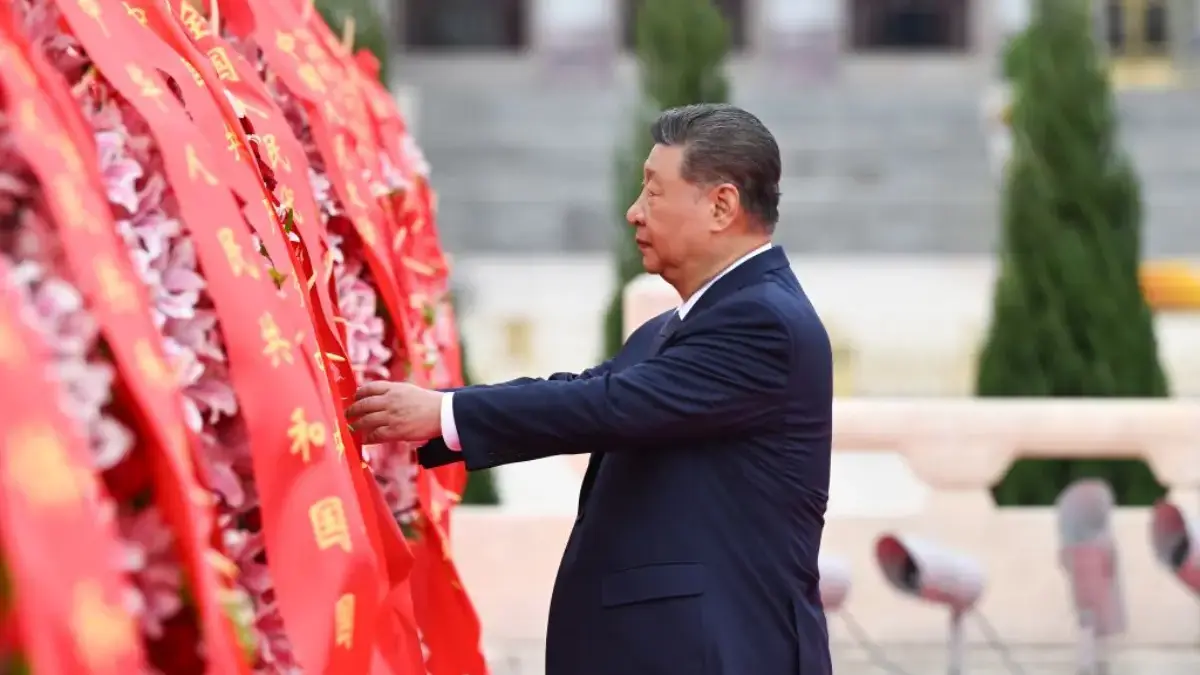 Presiden Tiongkok Xi Jinping merapikan pita pada keranjang bunga saat upacara pemberian karangan bunga kepada